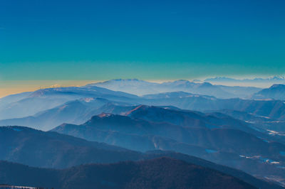 Scenic view of mountains against blue sky