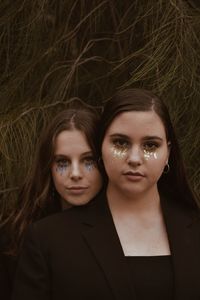 Portrait of female friends with glitters on face