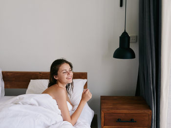 Young woman using mobile phone while sitting on table