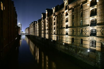 Canal amidst buildings against sky in city at night