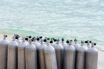 Close-up of bottles in row by sea