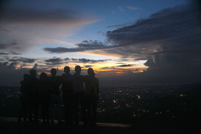 Silhouette people standing against sky during sunset