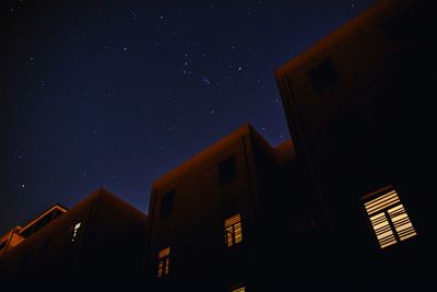 Low angle view of buildings against sky at night