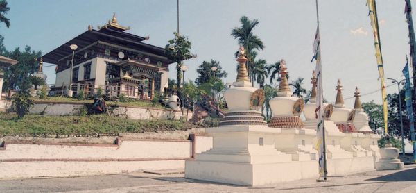 Statue amidst trees and building against sky