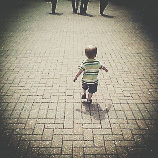 cobblestone, lifestyles, walking, street, full length, shadow, paving stone, footpath, rear view, leisure activity, high angle view, men, childhood, sidewalk, sunlight, boys, casual clothing