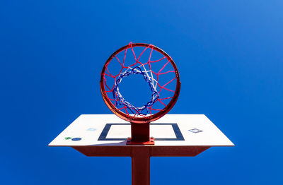 Low angle view of basketball hoop against blue sky