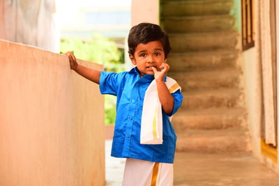 Portrait of boy wearing traditional clothing while standing in corridor