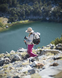 Woman standing on rock by river
