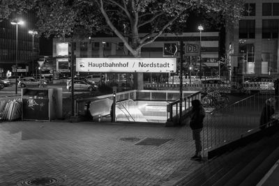 People on illuminated street in city at night