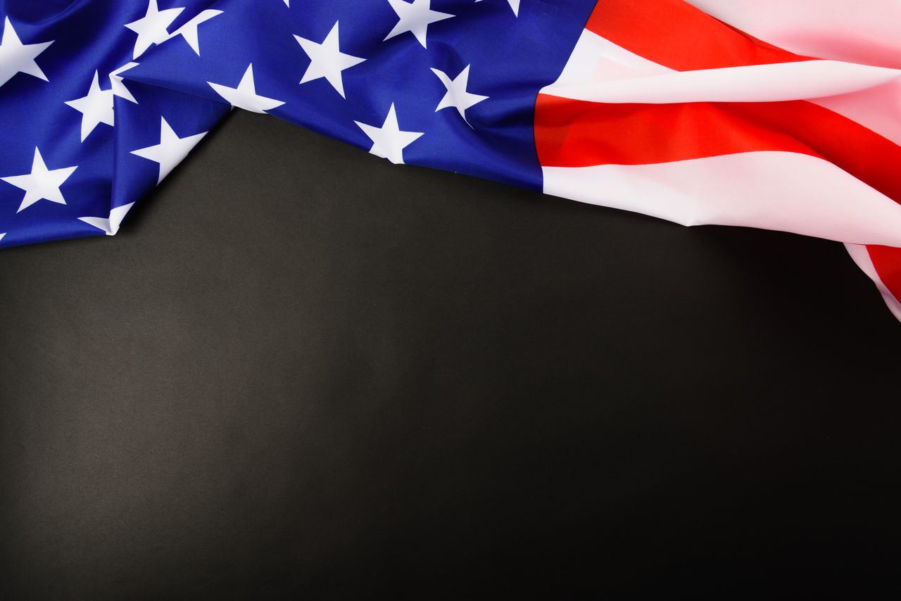 CLOSE-UP OF FLAGS AGAINST BLUE SKY