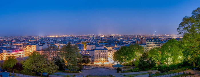 Illuminated cityscape against sky at night