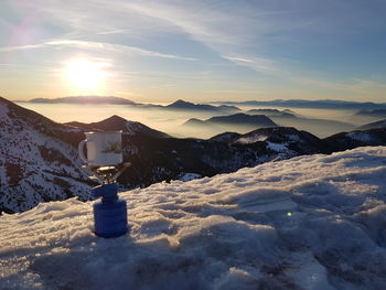 Snow covered mountain against sky during sunset