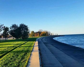 Empty road against clear blue sky