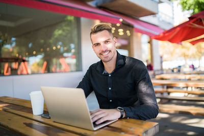 Portrait of a smiling young man using smart phone