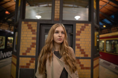 Beautiful young woman standing at subway station