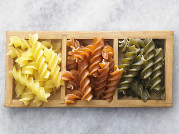 Close-up of colorful fusilli pasta in container on table