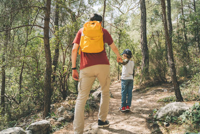 Rear view of woman standing in forest