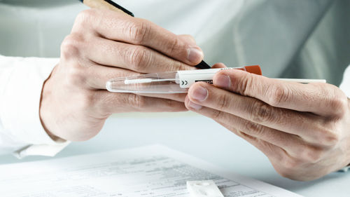 Doctor writes covid swab results on test tube