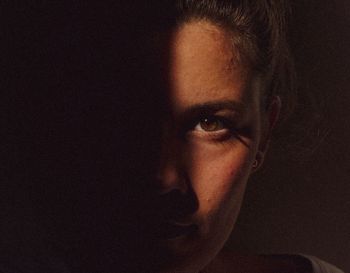 Close-up portrait of young man against black background