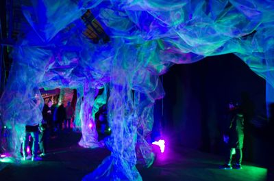 Full length of woman standing at illuminated nightclub