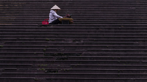 Rear view of woman sitting on staircase