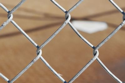 Home plate at softball field just beyond backstop 