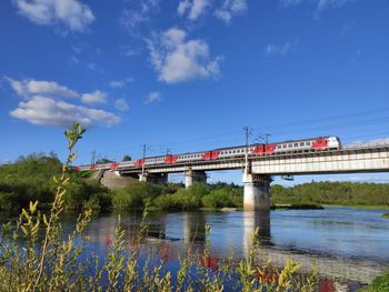 View of bridge over river against blue sky