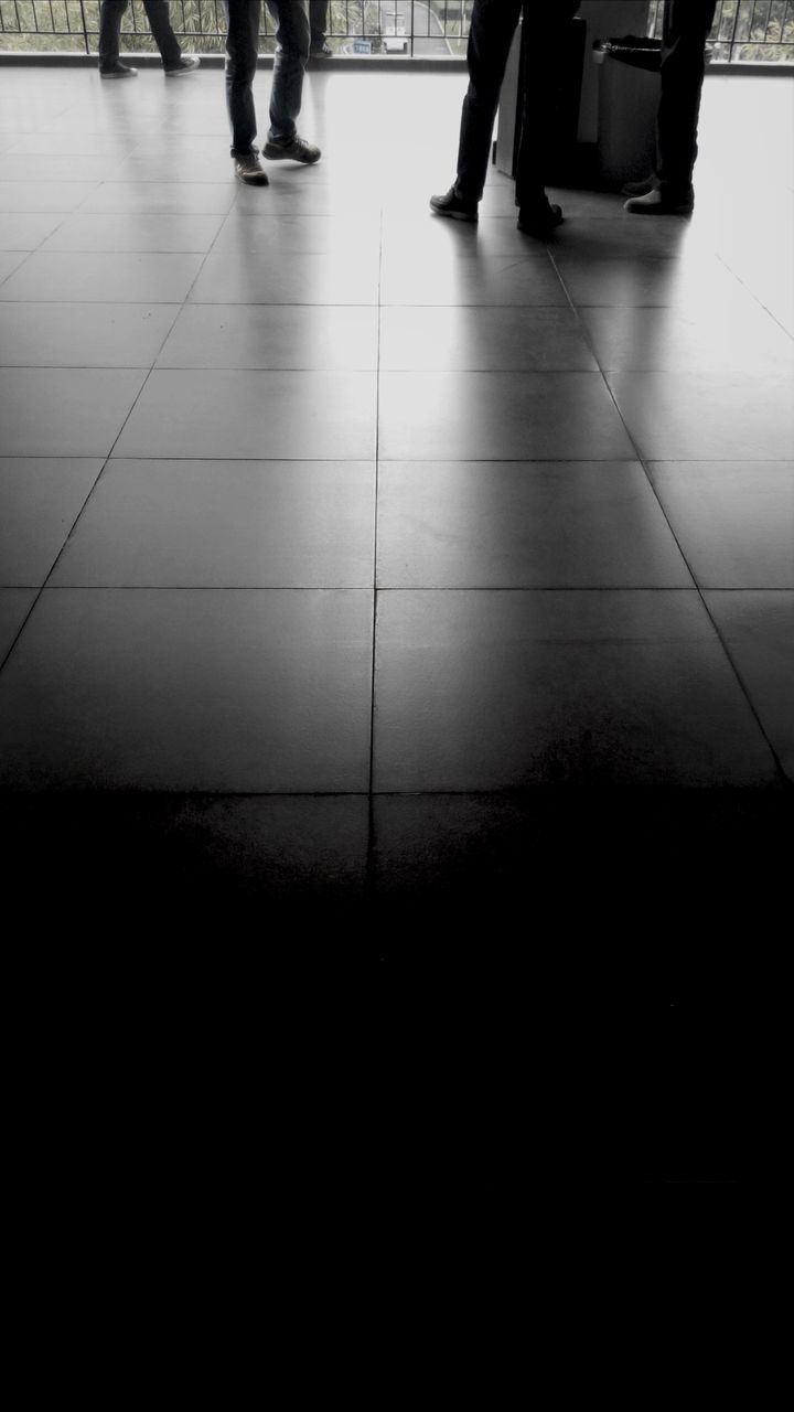 low section, indoors, person, men, tiled floor, walking, flooring, lifestyles, transportation, shadow, unrecognizable person, high angle view, on the move, human foot, silhouette, leisure activity