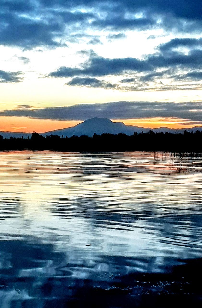 water, sky, reflection, cloud, scenics - nature, beauty in nature, sea, tranquility, nature, tranquil scene, horizon, sunset, shore, no people, dusk, ocean, mountain, evening, coast, wave, environment, idyllic, outdoors, landscape, dramatic sky, non-urban scene, sunlight, body of water, land, afterglow, travel destinations