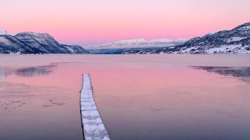 Scenic view of frozen lake against sky during sunrise