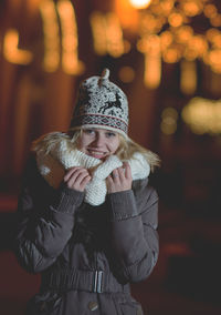 Woman standing on road in city at night