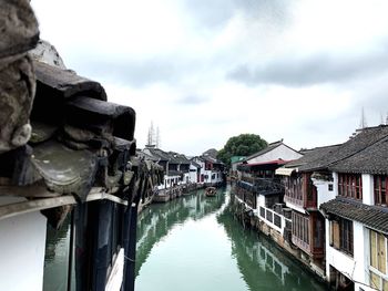 Canal amidst buildings against sky