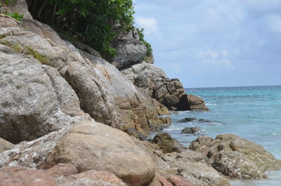 Rocks on sea shore against sky