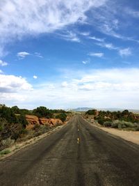 Road amidst trees against sky