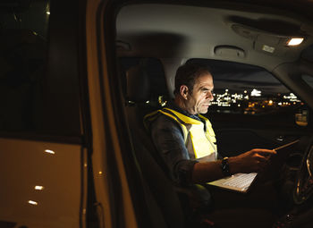 Engineer using laptop in car at night