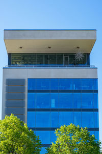 Low angle view of modern building against blue sky