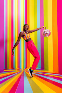 Full length of woman wearing costume against multi colored background