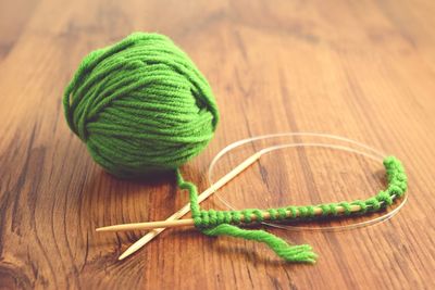 Knitting ball of wool with needle on wooden table