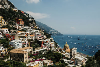 High angle view of townscape by sea against sky