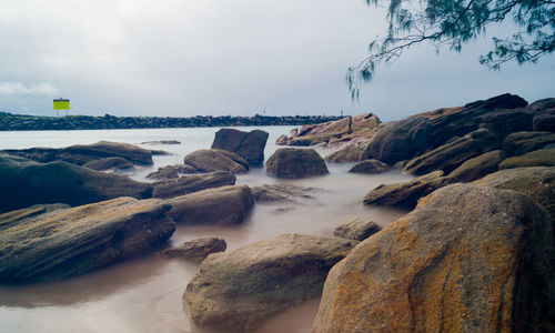 Rocks on beach against sky