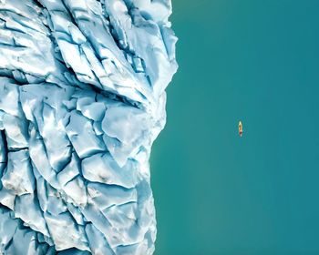 Aerial view of boat on sea by glacier