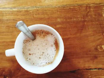 Directly above shot of coffee cup on wooden table