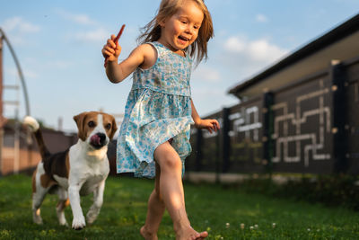 Portrait of young woman with dog on field