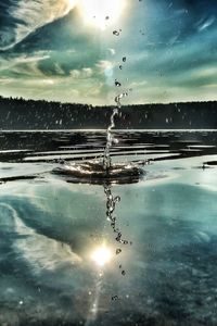 Close-up of snow on water against sky during sunset