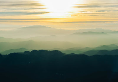 Scenic view of silhouette mountains against sky at sunset