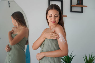 Portrait of young woman standing at home