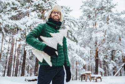 Woman standing on snow covered tree