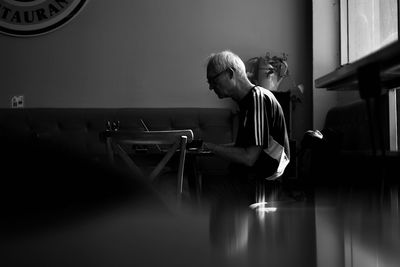 Side view of senior man sitting at table