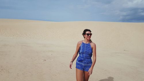 Young woman standing on sand at beach