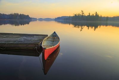 Red canoe on a calm summer morning at a lake